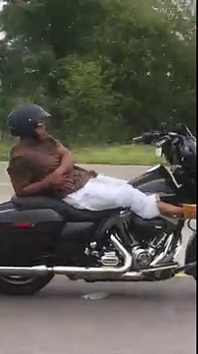 Un motard allongé sur sa Harley Davidson en ple...