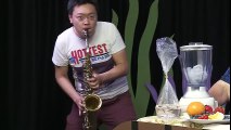 Asian man playing sultry sax while an older woman has a frozen blended drink prepared for her off camera