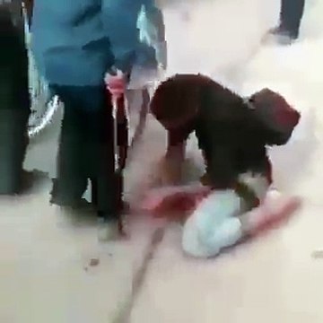 A man cleaning the shoes of the Zawar of Imam Hussain (as) during walk from Najaf to Karbala Arbaeen.