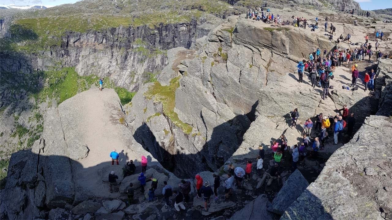 Des randonneurs font la queue pour une photo sur un rocher
