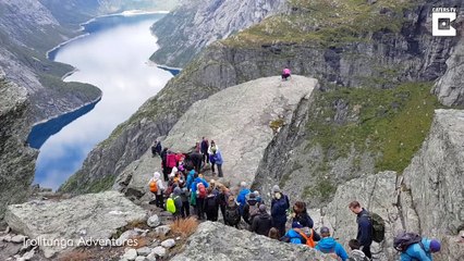 Des randonneurs font la queue pour une photo sur un rocher