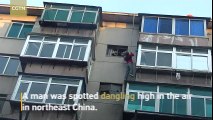 Firefighters rescue man dangling from top of building in northeast China