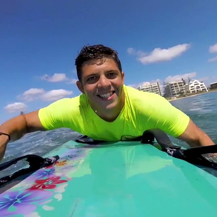 Un baleineau vient jouer avec un surfeur