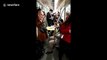 Boy does homework on carry-on folding table in subway carriage