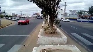 Uma senhora jogando pedra em carros que passavam por uma avenida em Juazeiro-BA