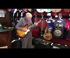 81 летний дедушка проверяет гитару перед покупкой