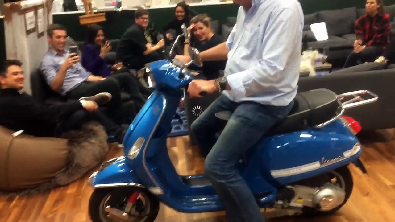 Jeremy Clarkson is riding Scooter Motorcycle indoors in the Office
