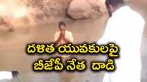 BJP leader beats 2 Dalits with stick : బురద నీటిలో మునగాలని