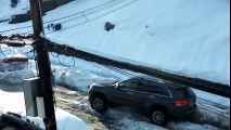 Un homme galère à sortir sa voiture à cause de la neige