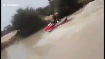 Man rides around flooded Algerian streets on a jetski