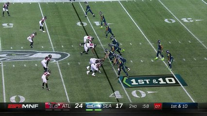 Russell Wilson dips between two Falcons pass rushers for first down