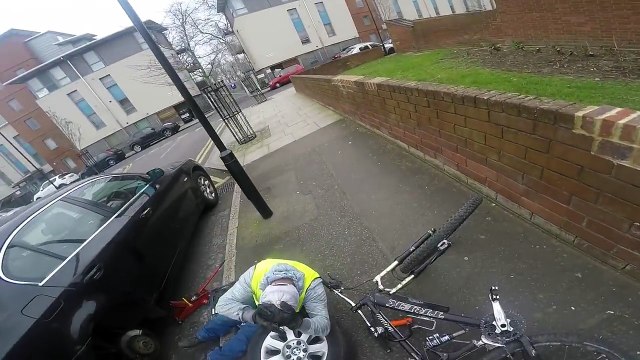 Un cycliste chute sur un homme qui changeait sa roue