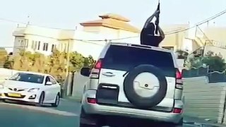 Arab holding gun out of sunroof in midst of a village in Israel