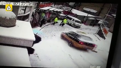Taxi slips and slides crashing into a police officer