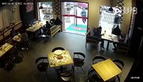 Un homme brise la porte en verre d'un restaurant
