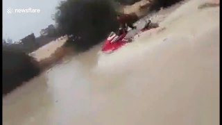 Man rides around flooded Algerian streets on a jetski