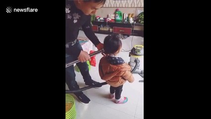 Dad creates cute ponytail on daughter with vacuum cleaner
