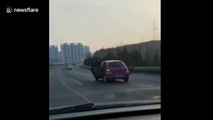 Car drives along motorway with both back doors OPEN