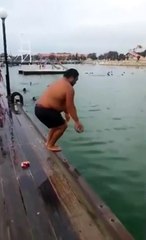 Il saut dans l'eau avec un ballon à la main