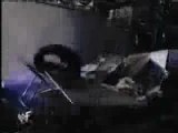 Undertaker chokeslams RVD off the stage and through two ta