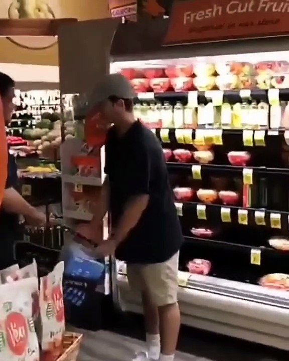 Un jeune ivre pense qu’il va pouvoir sortir avec ses paniers plein d’alcool sans payer