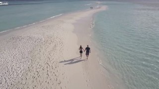 Couple Walking on a Beach Filmed with a Drone.mp4