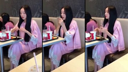 Une asiatique boit de l'eau après avoir mit du rouge à lèvres..