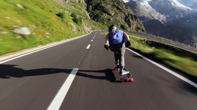 Il réalise une descente à toute vitesse en longboard