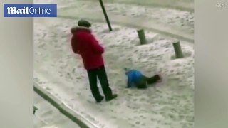 Father kicks his child because he slipped in the snow