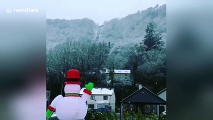 Santa goes surfing in Wales during snowfall