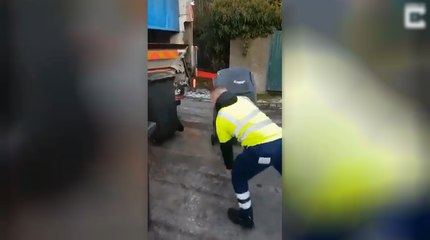 Un éboueur en galère avec des poubelles.