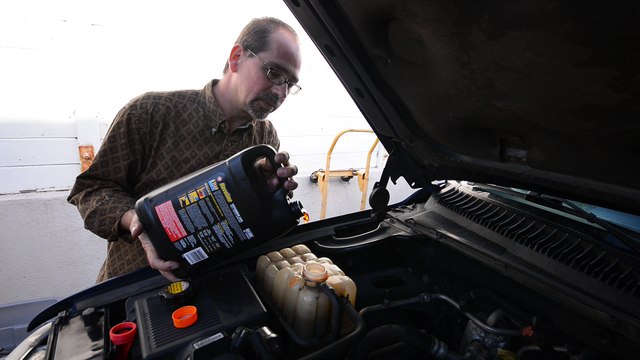 Pouring radiator fluid into your car