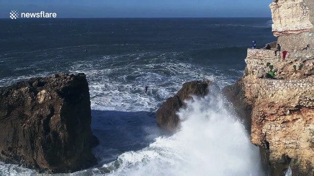 Nerve-racking slackline walk over huge waves in Nazaré, Portugal