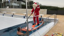 Le père Noël arrive en paddle à la piscine
