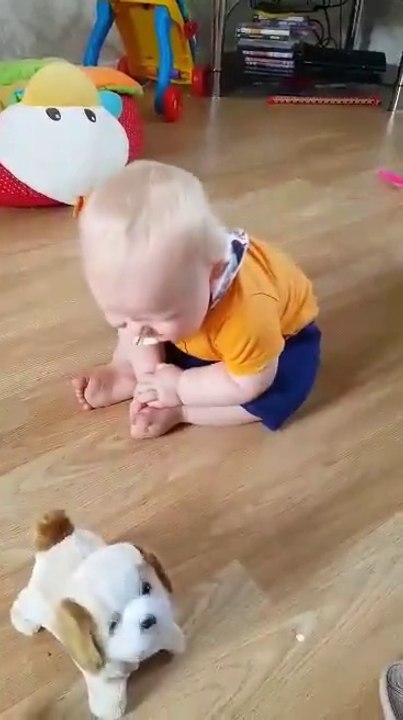 Ce bébé aime tellement son nouveau jouet... Il en est plié de rire
