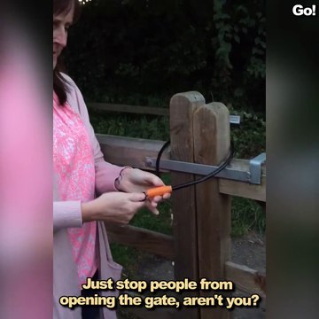 Cette femme un peu débile ne comprend pas comment fermer ce portail avec un cadenas anti-vol