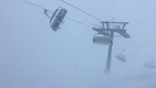 Deux skieurs bloqués sur un télésiège en pleine tempête.