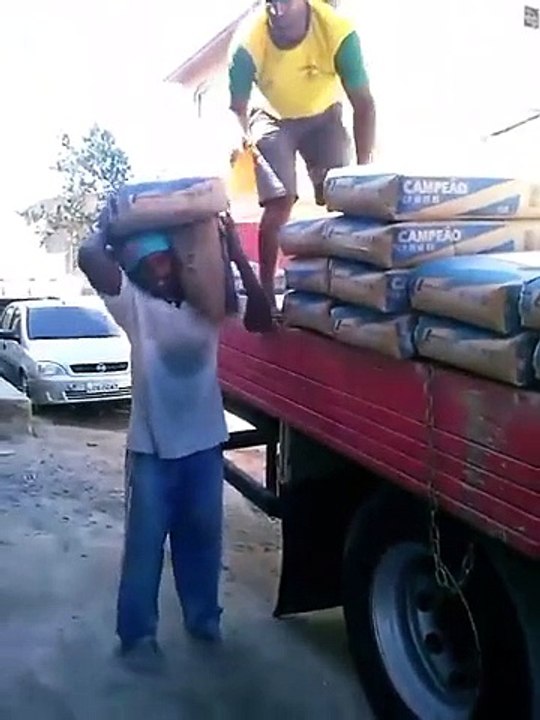Ce gars costaud porte des sacs de ciment cinq par cinq, poids de 250 kg
