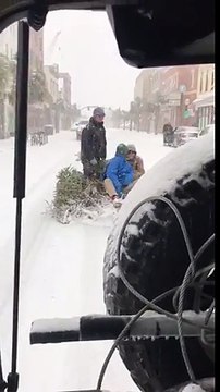 Tirés par une voiture... sur un sapin en pleines rues enneigées !