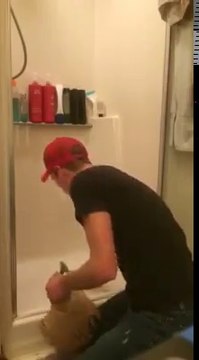 Il essaie de nous montrer comment retirer la touffe de cheveux coincé dans le siphon de la douche