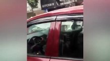 Nữ tài xế vừa cầm bát ăn vừa lái ô tô trên phố Hà Nội