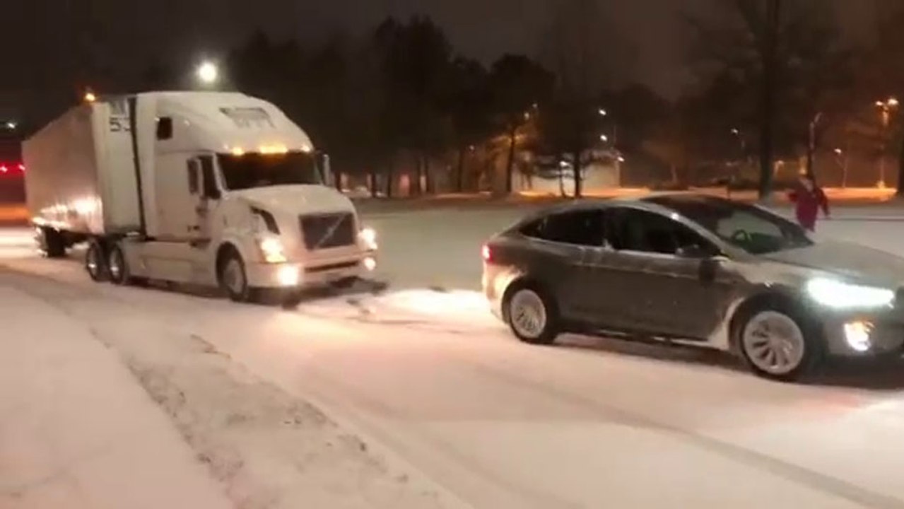 Une Tesla model X tracte un semi-remorque dans une pente enneigée