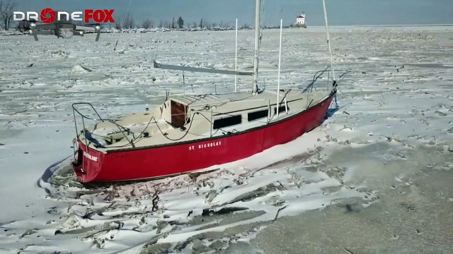 Sailboat Stuck in Icy Harbor Hundreds of Yards from Shore