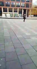 Deux personnes passent au mauvais moment sur une place balayée par le vent