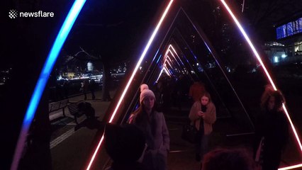 People walk through light sculpture in Lumiere London festival