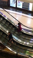 Woman Tries to Walk up Wrong Side of Escalator
