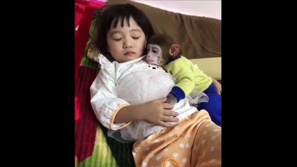 Little girl sleeping with her pet monkey