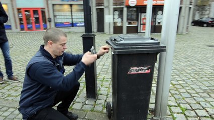 Opération Coup de propre à Huy - Un agent constatateur relève le numéro d'une poubelle sortie trop tôt dans la rue