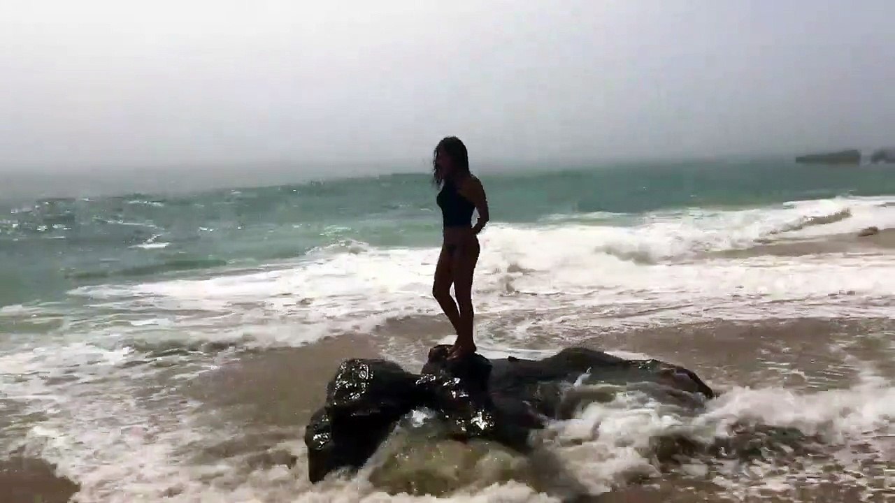Quand une fille fait la belle au bord de la mer et finit par se prendre une grosse vague