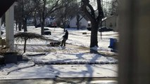 Un homme tond la neige avec sa tondeuse